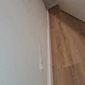 קיר עם קילוף צבע ליד רצפת עץ