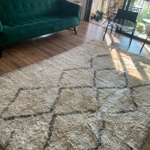 שטיח בהיר עם דוגמאות על רצפת עץ