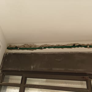 תעלה בקיר עם צינור חשמל ירוק חשוף