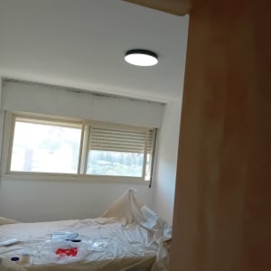 חדר עם קירות צבועים ומיטה מכוסה בניילון