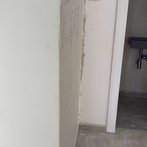 קיר עם טיח חלקי בתהליך צביעה