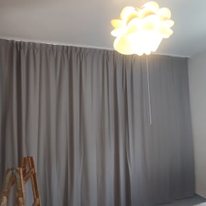 וילון אפור תלוי על קיר לבן בחדר