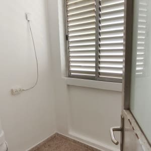 חדר קטן עם חלון ותריסים, קירות צבועים