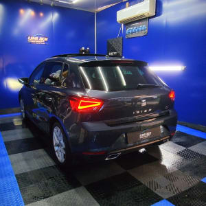 מכונית שחורה בחדר כחול עם תאורה חזקה