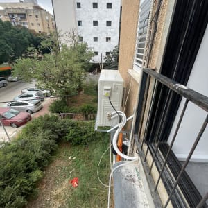 יחידת מזגן חיצונית מותקנת על קיר בניין