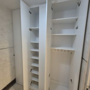 ארון לבן עם דלתות פתוחות ומדפים פנימיים