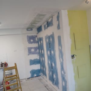 קיר גבס עם לוחות כחולים וסולם צהוב