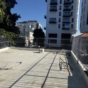 גדרות מתכת על גג בטון עם צללים ארוכים