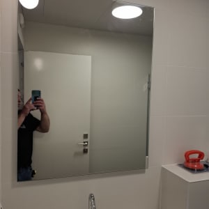 מראה בחדר אמבטיה עם כיור וברז