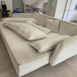 ספה לבנה עם כריות בסלון, כלי ניקוי ברקע