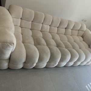 ספה מרופדת בצבע בהיר על רצפת אריחים