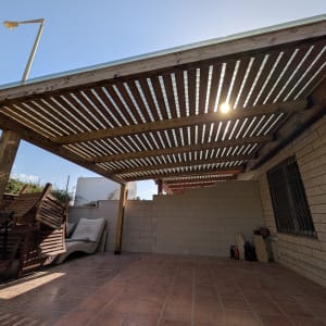 פרגולה מעץ בחצר עם ריהוט גן