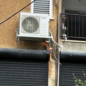 יחידת מיזוג אוויר חיצונית מותקנת על קיר בניין