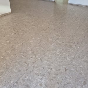 רצפה נקייה בחדר ריק עם מטבח ברקע