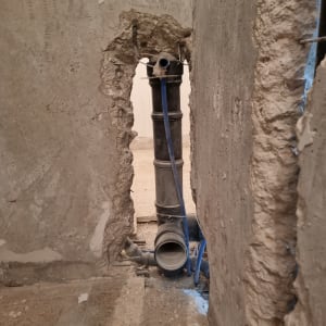 צינור ביוב חשוף בקיר במהלך שיפוץ