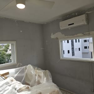 חדר עם קירות מתקלפים ומזגן, מוכן לצביעה