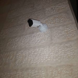 מצלמת אבטחה מותקנת על קיר אבן חיצוני