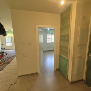 חדר עם דלת פתוחה, קירות צבועים, רצפה מרוצפת
