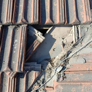 רעפים שבורים על גג עם חור