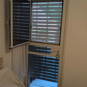 תריסים פתוחים למחצה על חלון זכוכית