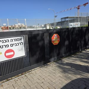 שער חשמלי עם שלט איסור כניסה לרכבים פרטיים