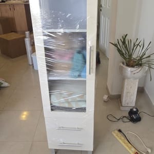 ארון תצוגה לבן עטוף בניילון נצמד להגנה במהלך הובלת דירה