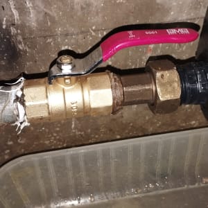 ברז כדורי עם ידית אדומה וצינור מתכת