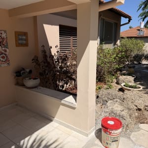 חצר וכניסה לבית פרטי לצד פח צבע במהלך שיפוץ קוסמטי
