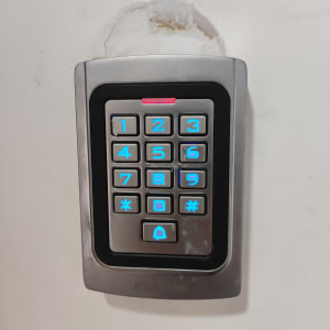 לוח מקשים עם תאורה כחולה על קיר לבן