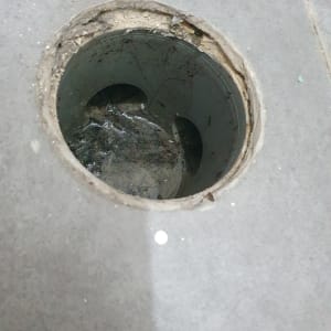 פתח ניקוז עגול ברצפה עם לכלוך בפנים