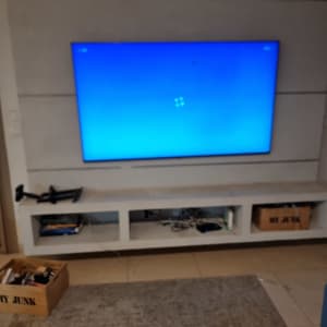 טלוויזיה מותקנת על קיר עם מדף תחתון