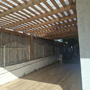 פרגולה מעץ עם רצפת דק בחצר