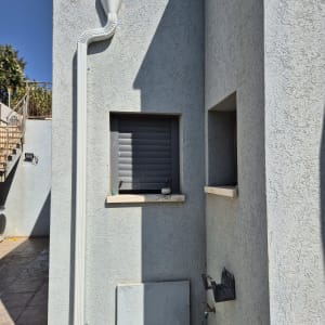 קיר חיצוני עם צינור ניקוז וחלון קטן