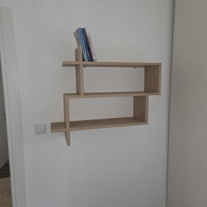 מדף עץ תלוי על קיר עם ספרים