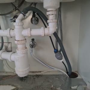 צנרת פלסטיק מתחת לכיור עם חיבורים וברזים