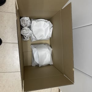 קופסת קרטון עם חפצים עטופים בנייר לאריזה