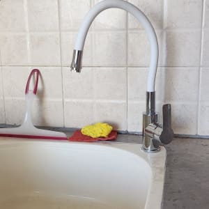 ברז מטבח עם צינור לבן, סמרטוט צהוב