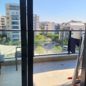 מרפסת עם חלונות זכוכית ונוף לבניינים