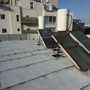 גג עם קולטי שמש ודודי מים, קשור לאיטום