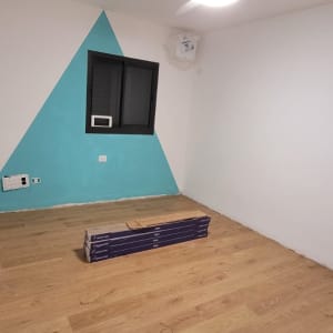 חדר עם פרקט עץ ותקרה עם מאוורר