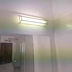 מנורה על קיר חדר אמבטיה עם מקלחת