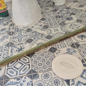 רצפת מקלחת עם אריחים מעוצבים ובקבוק חומר ניקוי