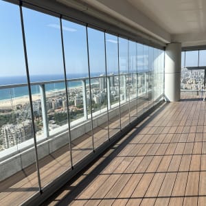 מרפסת עם נוף לים ולבניינים, חלונות זכוכית גדולים