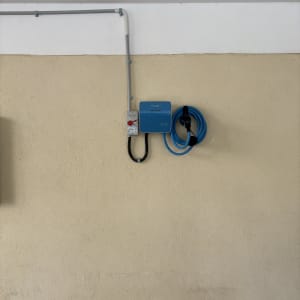 מטען חשמלי עם כבל כחול על קיר