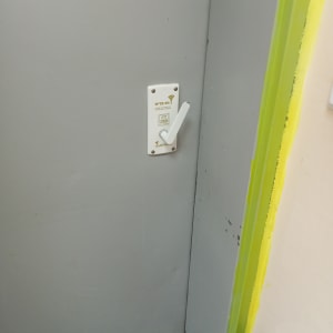 ידית דלת לבנה עם מנעול על דלת אפורה