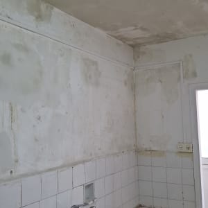 קיר ותקרה עם סימני רטיבות ועבודת טיח