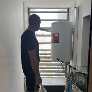 אדם מחזיק שקית ליד דוד שמש ומסנן רשת