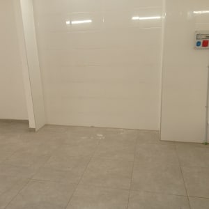 חדר ריק עם קירות לבנים ורצפת אריחים
