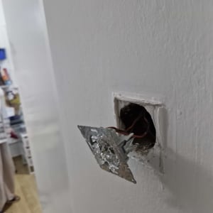 שקע חשמלי פתוח עם חוטים חשופים בקיר