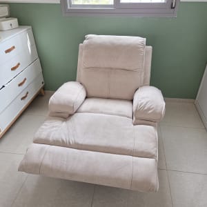 כורסה בחדר עם קיר ירוק ורהיטים לבנים